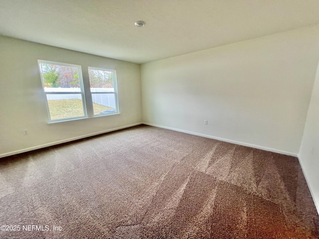 empty room featuring carpet floors and baseboards