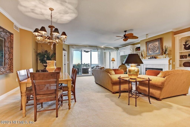 dining space featuring light carpet, visible vents, baseboards, a tiled fireplace, and crown molding