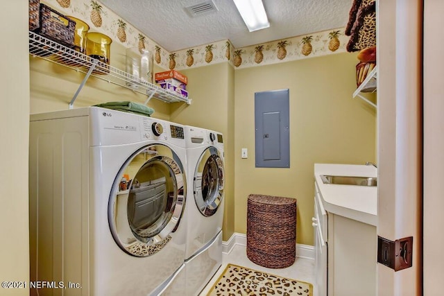 laundry room with electric panel, visible vents, a textured ceiling, and washing machine and clothes dryer