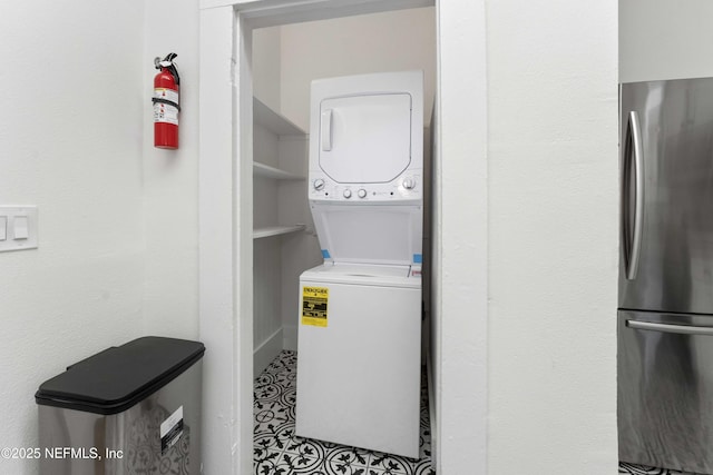 washroom with stacked washer / drying machine and laundry area