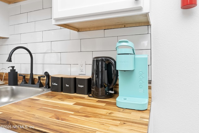 details featuring a sink, wooden counters, and backsplash