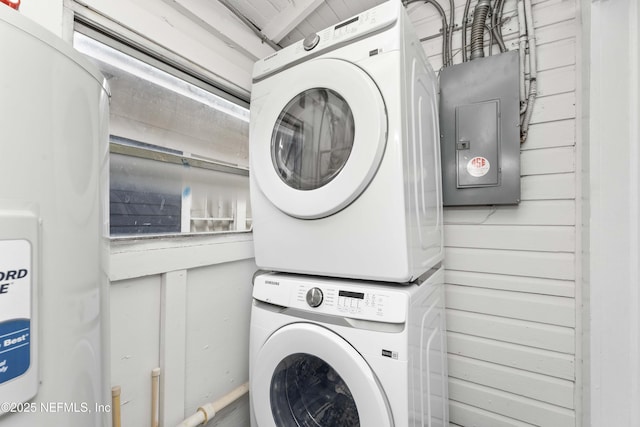 clothes washing area with laundry area, electric panel, and stacked washing maching and dryer