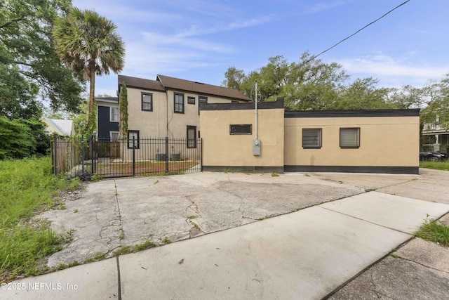 view of front of house featuring fence, a gate, and stucco siding