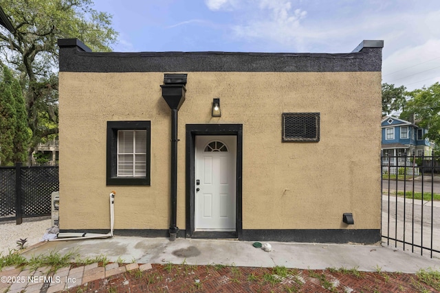 view of front of house with fence and stucco siding