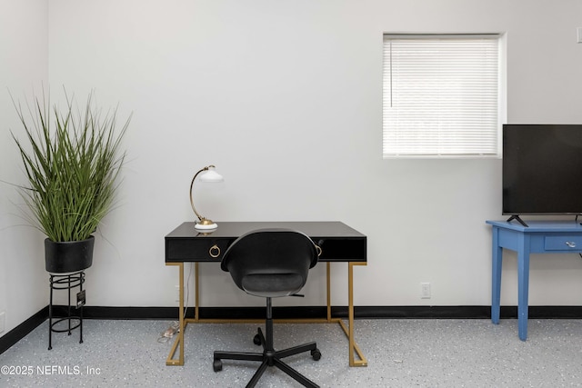 office featuring baseboards and speckled floor