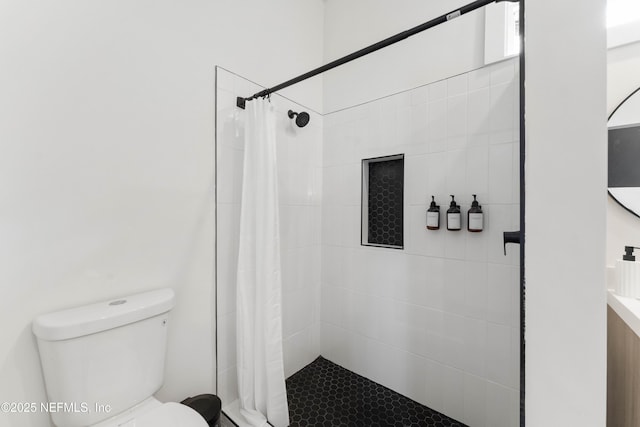 bathroom featuring toilet and tiled shower