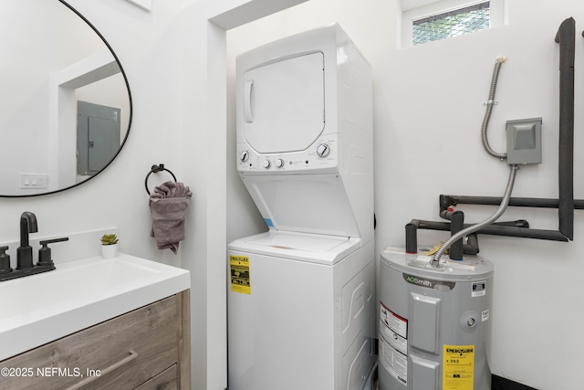 clothes washing area featuring a sink, laundry area, stacked washer and clothes dryer, and electric water heater