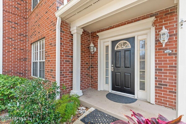 property entrance featuring brick siding