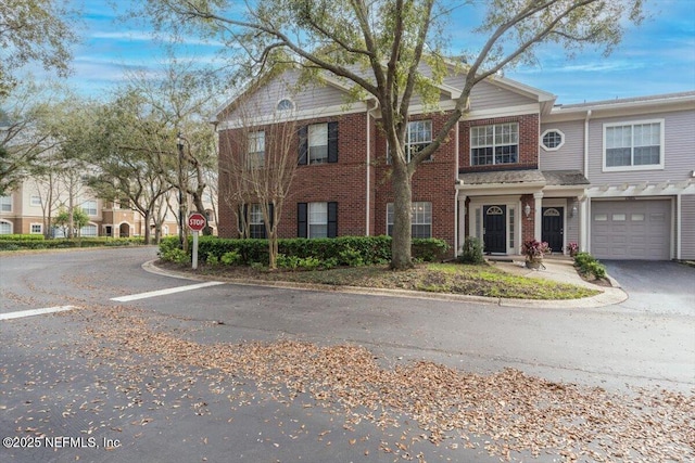 view of front of house featuring a garage, brick siding, and driveway