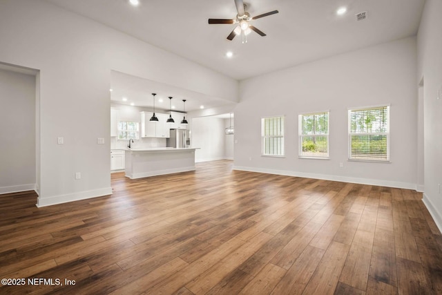 unfurnished living room with a ceiling fan, recessed lighting, a sink, and hardwood / wood-style flooring