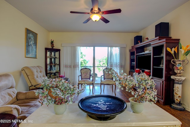 living area with a ceiling fan and wood finished floors