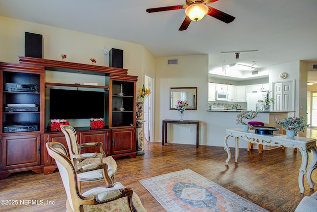 living room featuring ceiling fan, visible vents, and wood finished floors