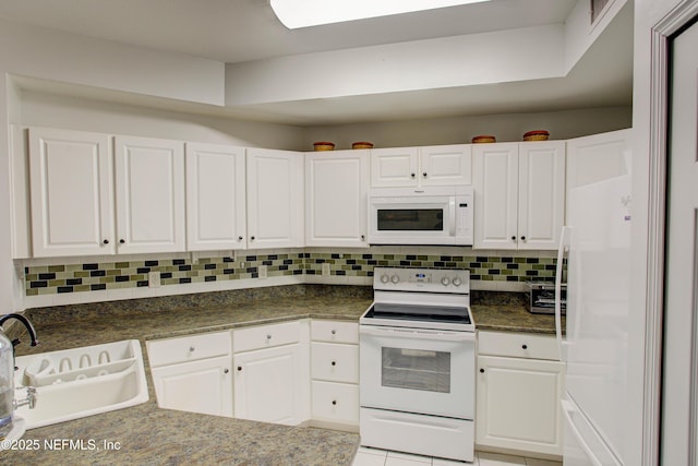 kitchen featuring white appliances, white cabinets, a sink, and decorative backsplash