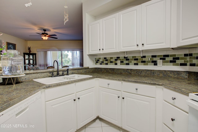 kitchen featuring tasteful backsplash, white dishwasher, white cabinetry, and a sink