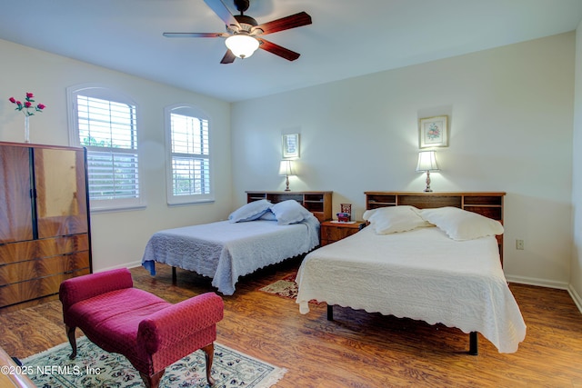 bedroom with ceiling fan, baseboards, and wood finished floors