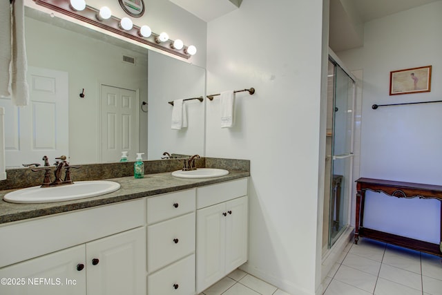 full bath featuring a stall shower, tile patterned flooring, a sink, and double vanity