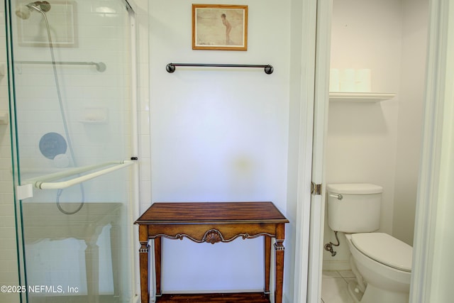 bathroom featuring tiled shower and toilet