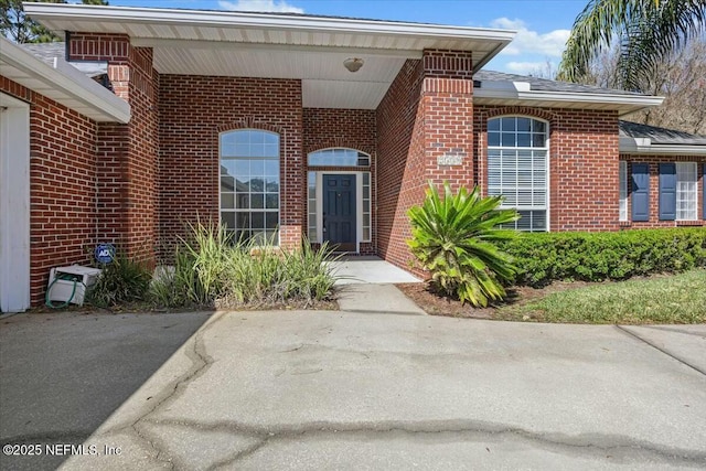 view of exterior entry featuring brick siding