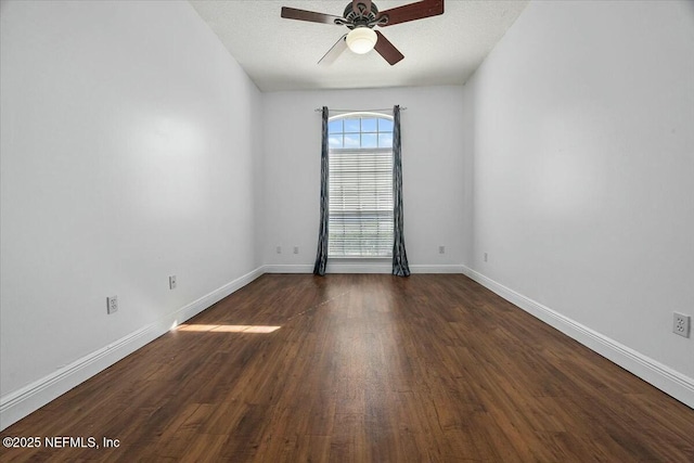 unfurnished room featuring a ceiling fan, a textured ceiling, baseboards, and dark wood-type flooring