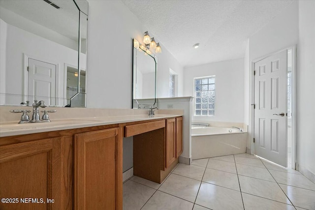 bathroom with double vanity, tile patterned floors, a sink, a textured ceiling, and a bath