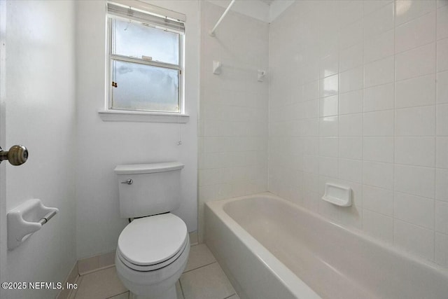 bathroom with tile patterned flooring, baseboards, shower / tub combination, and toilet