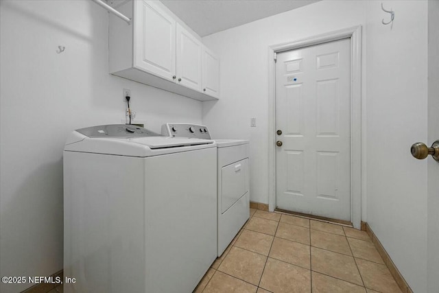 laundry area with cabinet space, independent washer and dryer, baseboards, and light tile patterned flooring