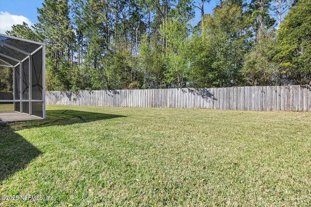 view of yard featuring glass enclosure and a fenced backyard