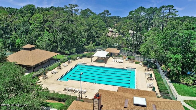 community pool with a patio area and fence