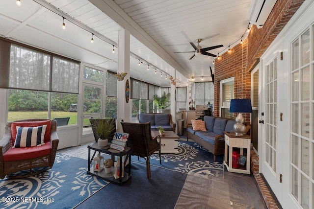 sunroom / solarium featuring rail lighting and a ceiling fan