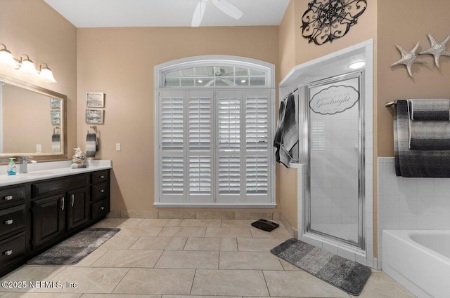 full bathroom featuring ceiling fan, vanity, a bath, tile patterned floors, and a stall shower