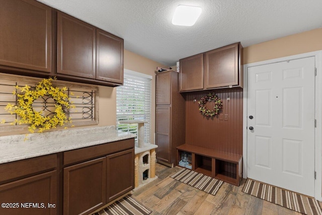 mudroom featuring light wood-style flooring and a textured ceiling