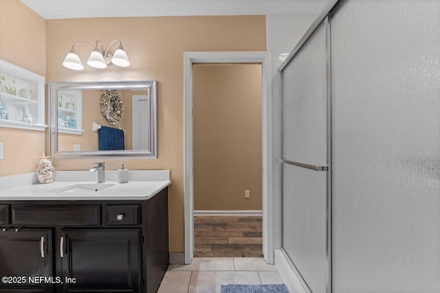 bathroom featuring tile patterned flooring, a shower stall, and vanity