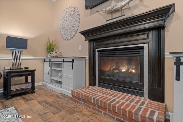 room details featuring a fireplace, baseboards, and wood finished floors