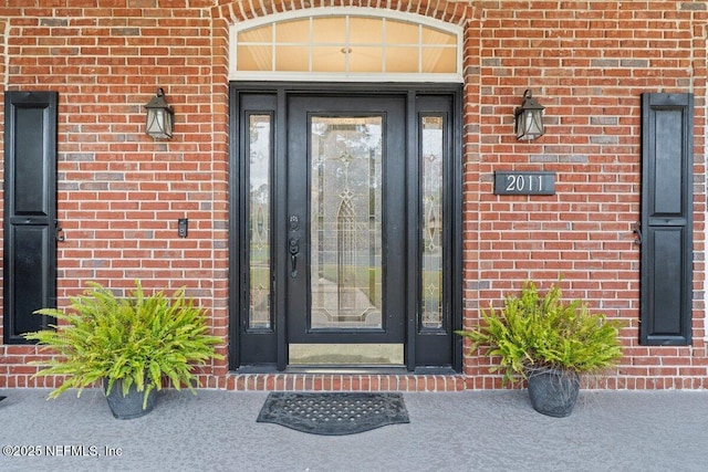 view of exterior entry with brick siding