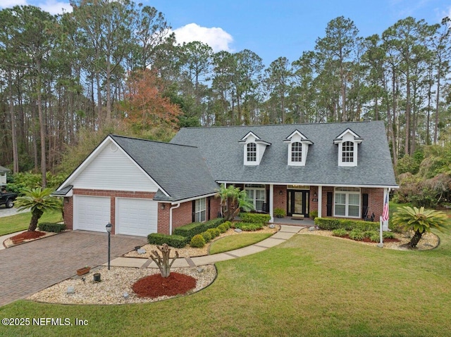 cape cod home featuring an attached garage, a front lawn, decorative driveway, and brick siding