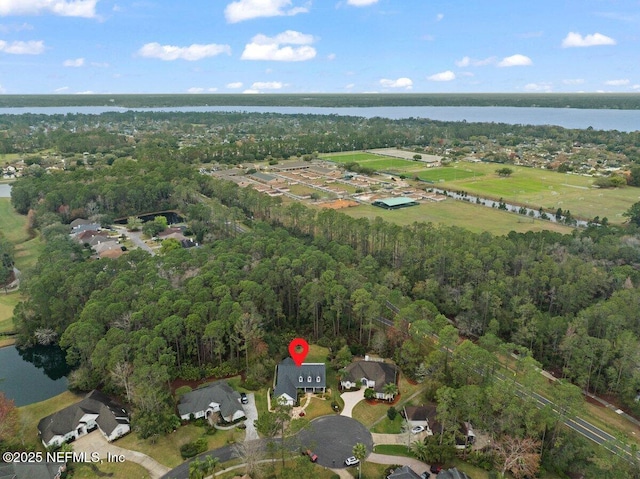 aerial view with a water view and a wooded view