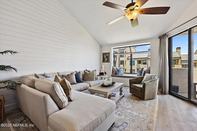 living room featuring high vaulted ceiling, wood finished floors, and a ceiling fan