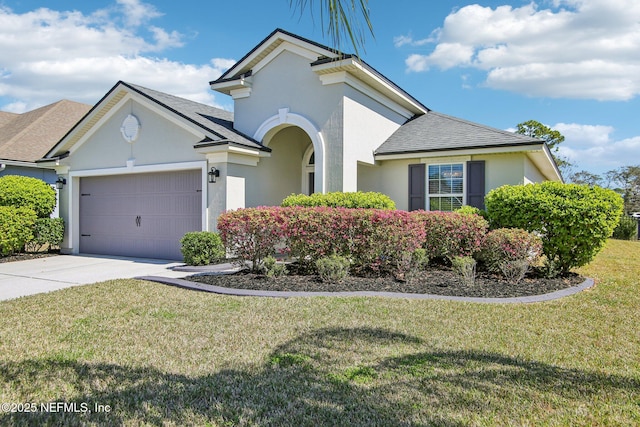 view of front of home featuring stucco siding, a shingled roof, concrete driveway, an attached garage, and a front yard