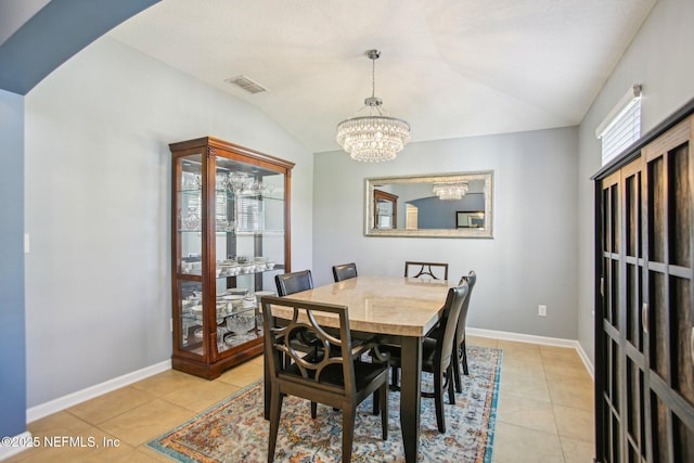 dining space featuring vaulted ceiling, light tile patterned floors, visible vents, and a notable chandelier