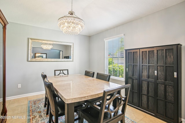 dining room featuring light tile patterned flooring, a notable chandelier, and baseboards