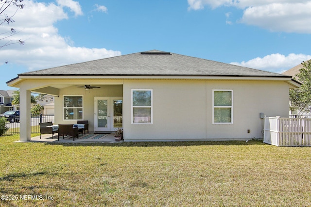 rear view of property featuring ceiling fan, a lawn, a patio area, and fence