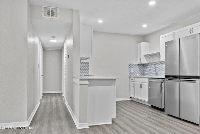 kitchen featuring visible vents, light wood-style floors, white cabinets, light countertops, and appliances with stainless steel finishes