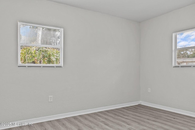 unfurnished room with baseboards and wood finished floors