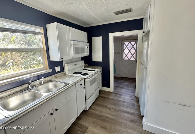 kitchen featuring white appliances, a sink, visible vents, and white cabinets