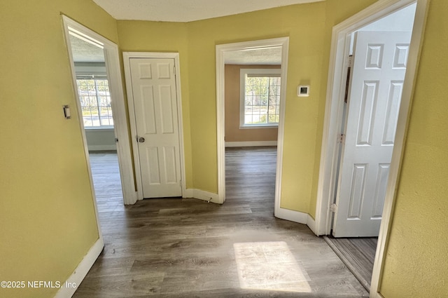 hallway featuring baseboards and wood finished floors