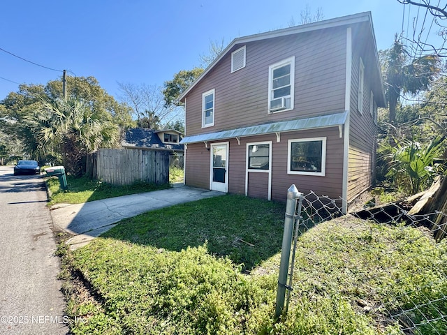 view of front of home featuring a front lawn and fence