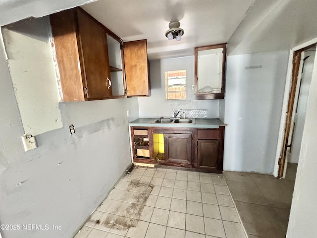 kitchen featuring light tile patterned floors, light countertops, and a sink