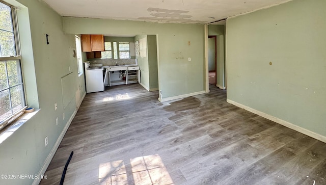 unfurnished living room featuring wood finished floors and baseboards