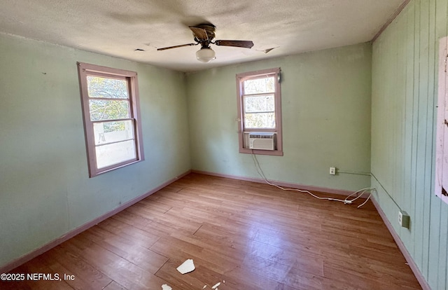 spare room featuring ceiling fan, a textured ceiling, baseboards, and wood finished floors