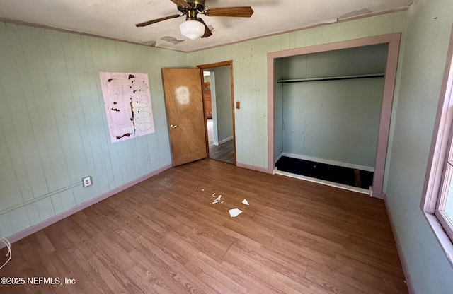 unfurnished bedroom featuring a closet, baseboards, and wood finished floors